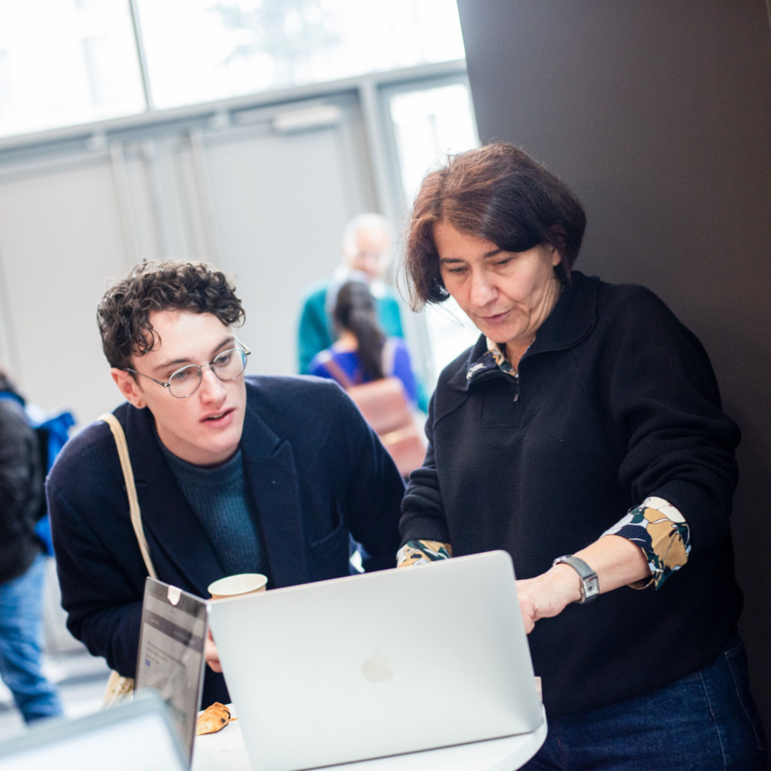 Sur cette photo, deux personnes, un jeune homme et une femme, regardent attentivement l'écran d'un ordinateur.